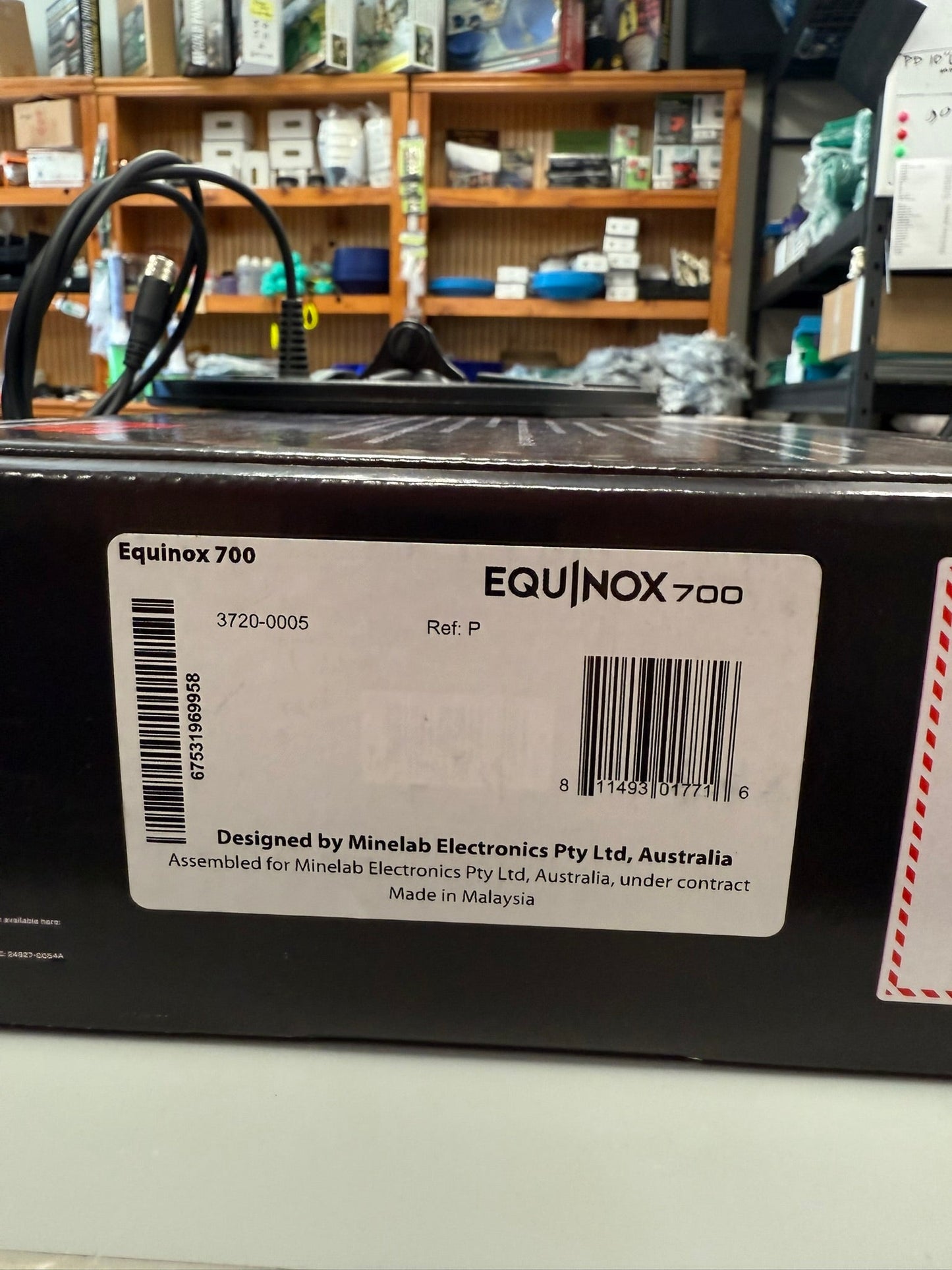 Minelab Equinox 700 metal detector with a label on a shelf in a store.